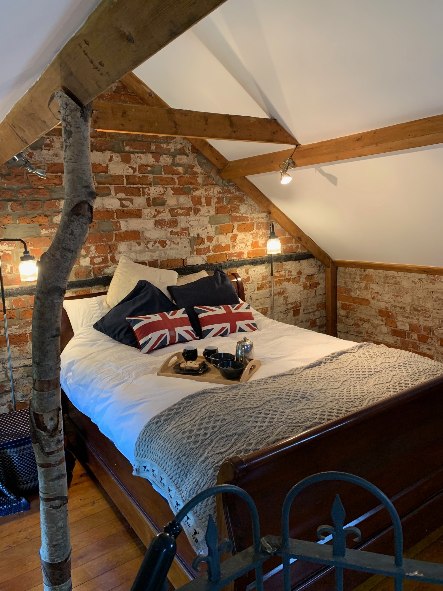 King size mezzanine bedroom with exposed brick and oak beams